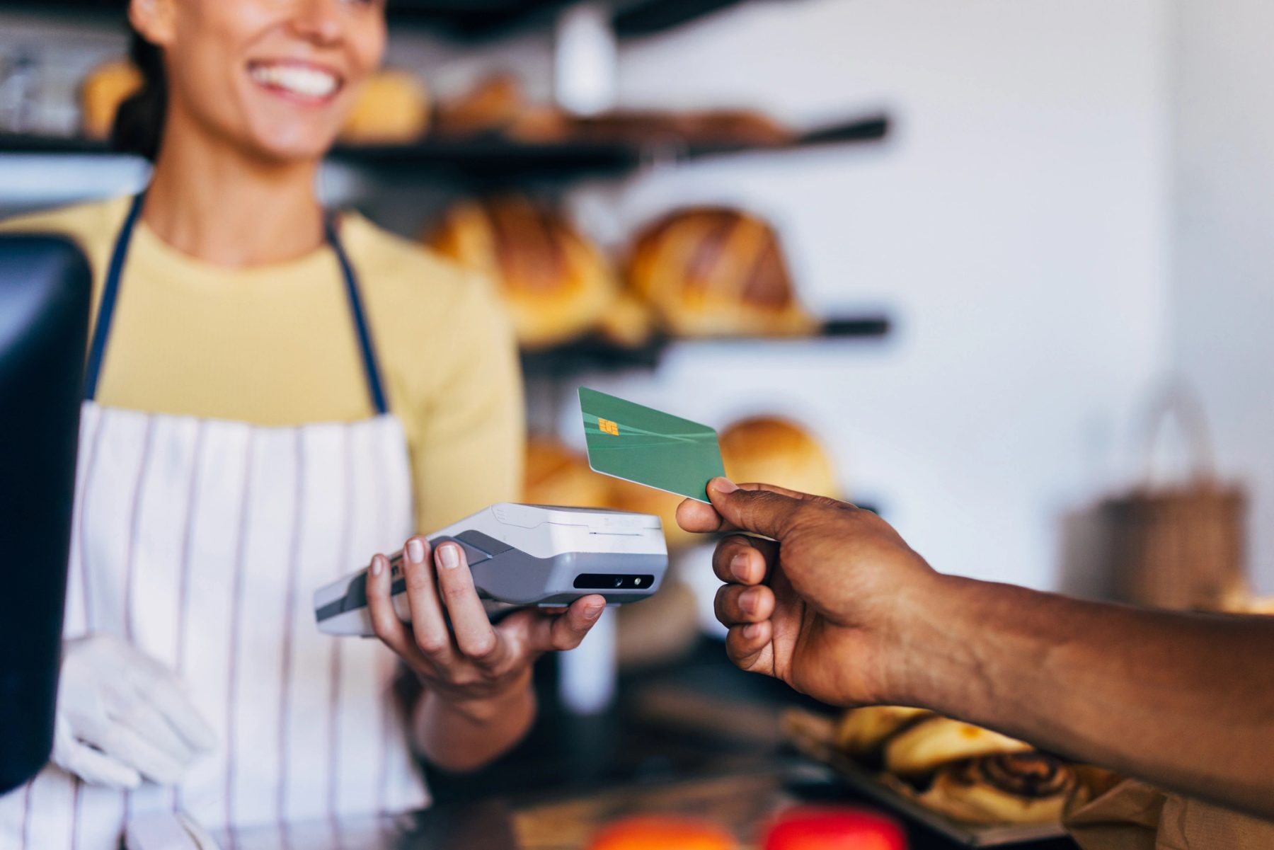 A customer paying with a card at a bakery counter